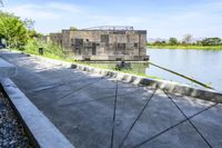 a small boathouse on the side of the river with people walking in it near it