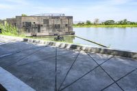 a small boathouse on the side of the river with people walking in it near it