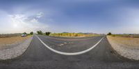 the image is 360 view, showing two white lines in between a desert area and one road