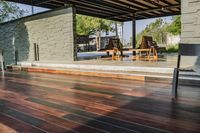 a deck in the backyard with table, chairs, and fire pit near by the pool