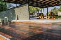 a deck in the backyard with table, chairs, and fire pit near by the pool