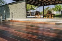 a deck in the backyard with table, chairs, and fire pit near by the pool