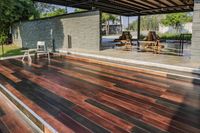 a deck in the backyard with table, chairs, and fire pit near by the pool