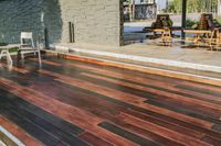 a deck in the backyard with table, chairs, and fire pit near by the pool