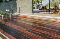 a deck in the backyard with table, chairs, and fire pit near by the pool