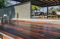 a deck in the backyard with table, chairs, and fire pit near by the pool