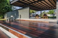 a deck in the backyard with table, chairs, and fire pit near by the pool