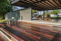 a deck in the backyard with table, chairs, and fire pit near by the pool