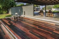 a deck in the backyard with table, chairs, and fire pit near by the pool