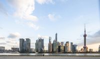 the view of a city from a bridge in shanghai, china from a distance is a red boat in the water