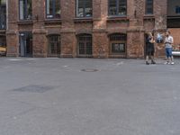 three men playing a game of frisbee in front of a building in a city