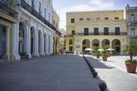 three young people are walking down a city square in front of old buildings and palm trees