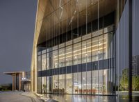 modern glass walled office building near water fountain in night time atmosphere of city business park