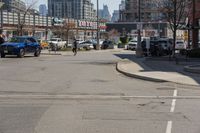 this is the intersection where some pedestrians and cars are crossing on a sunny day in a city