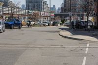 this is the intersection where some pedestrians and cars are crossing on a sunny day in a city