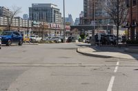 this is the intersection where some pedestrians and cars are crossing on a sunny day in a city