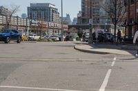 this is the intersection where some pedestrians and cars are crossing on a sunny day in a city