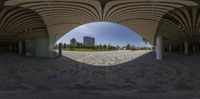 an empty parking lot under a wooden canopy with glass doors and arched columns, which covers the area from sunlight