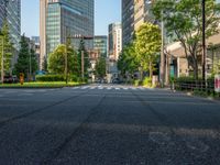 an empty road with a street sign at the curb in front of an office building