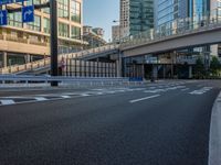 an empty road with a street sign at the curb in front of an office building