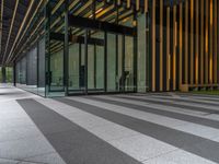 a walkway leading up to a wooden wall next to a cement area with floor tiles