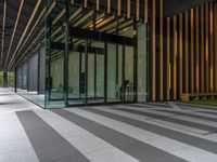 a walkway leading up to a wooden wall next to a cement area with floor tiles