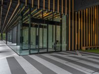 a walkway leading up to a wooden wall next to a cement area with floor tiles