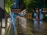 a large brick sidewalk with a store front at night time and a sign that says