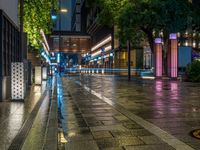 a large brick sidewalk with a store front at night time and a sign that says