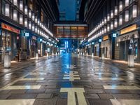 a large brick sidewalk with a store front at night time and a sign that says