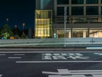 an image of outside of the night time building with the lights turned on and the streets empty