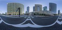 a long curved road with white street marking and high buildings in the background in a city