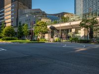 an empty road with a street sign at the curb in front of an office building