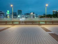 people standing on a subway platform with many buildings in the background at night light in tokyo