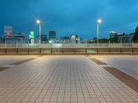 people standing on a subway platform with many buildings in the background at night light in tokyo