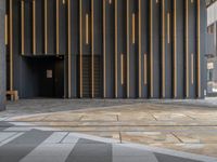 a walkway leading up to a wooden wall next to a cement area with floor tiles