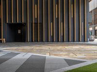 a walkway leading up to a wooden wall next to a cement area with floor tiles