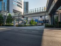 an empty road with a street sign at the curb in front of an office building