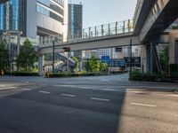 an empty road with a street sign at the curb in front of an office building