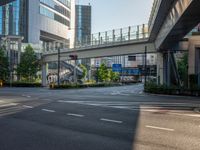 an empty road with a street sign at the curb in front of an office building