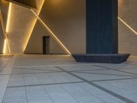 a hallway with columns on the wall that have led lights coming out of them and a door is behind the wall