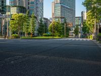 an empty road with a street sign at the curb in front of an office building