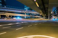 the view of a long exposure of a freeway bridge at night with light streaking down