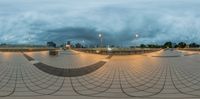 a 360 - ball view of an empty skate park with concrete floors and benches at the bottom of the circle