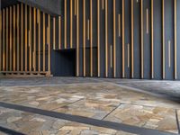 a walkway leading up to a wooden wall next to a cement area with floor tiles