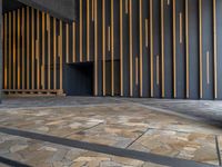 a walkway leading up to a wooden wall next to a cement area with floor tiles