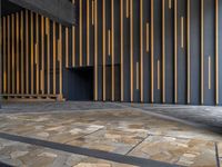 a walkway leading up to a wooden wall next to a cement area with floor tiles