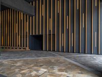 a walkway leading up to a wooden wall next to a cement area with floor tiles