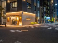 a small street corner at night in a city area and lit up by various light fixtures