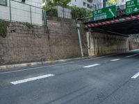 two trucks are driving under a bridge in a city streets area of an urban area